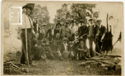 Grupo de hombres comiendo un asado